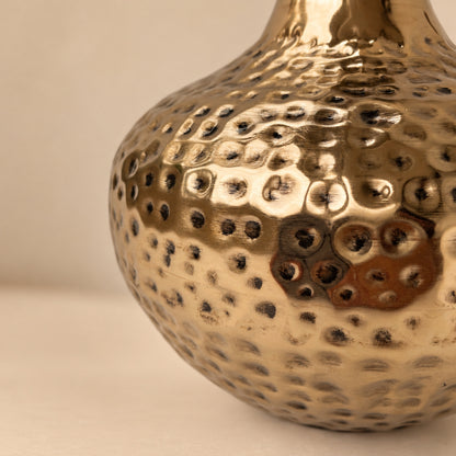 Close-up of the hammered champagne gold surface of the Oria vase with antique black indents