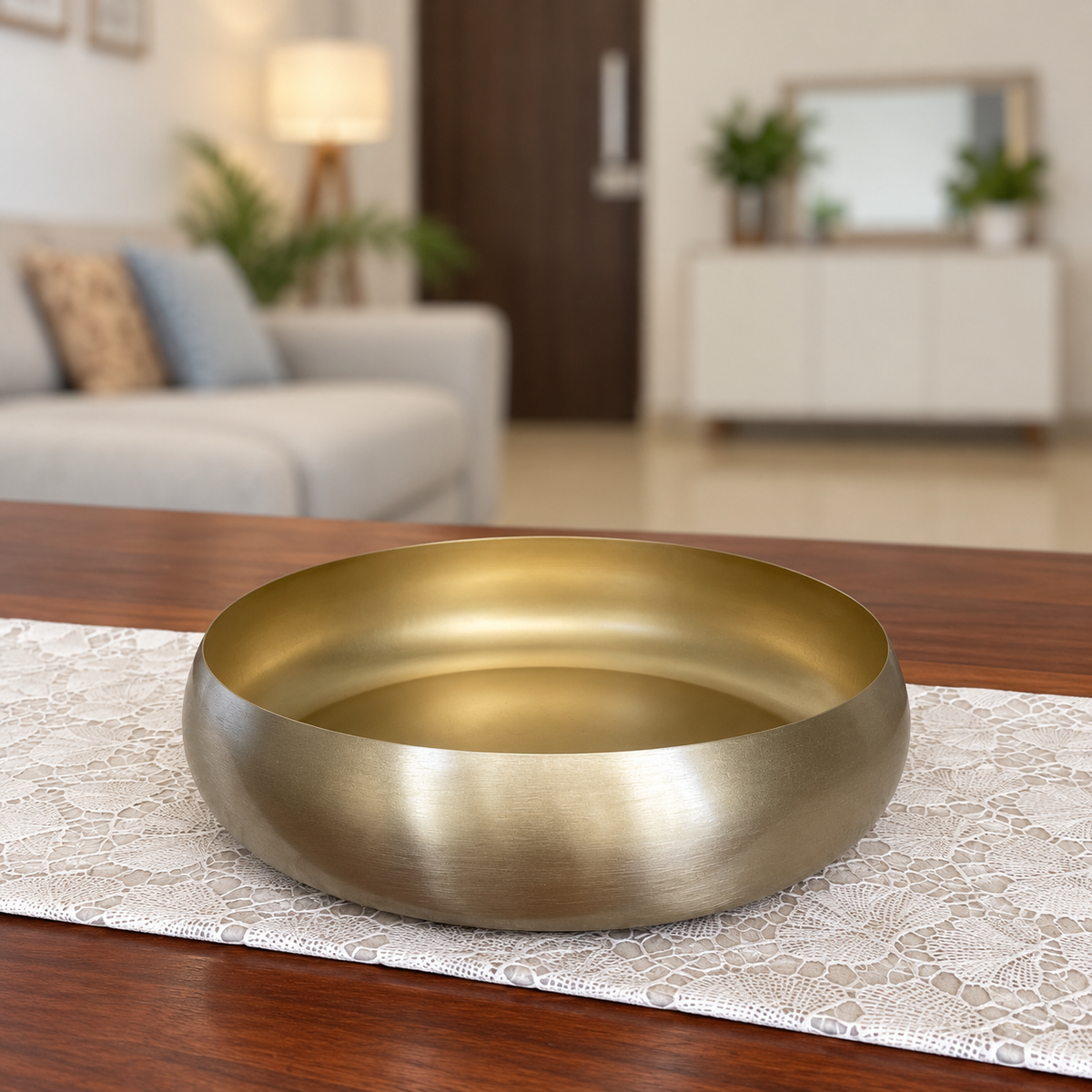 Ekam Metal Urli 10 inch, a brass-finish bowl on a lace runner on a wooden table