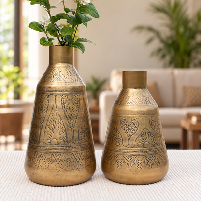 Aurum 15 inch and 12 inch antique brass finish vases together in a living room, one with jasmine flowers