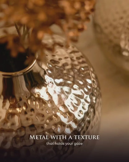 Close-up of the hammered silver finish on the Oria globe vase catching the light